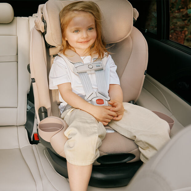 A child smiling while seated in a Callisto G 360 rotating convertible car seat in a car.
