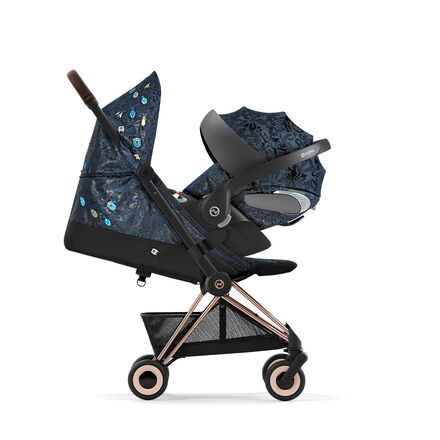 Stroller with blue floral pattern and gold accents, side view.