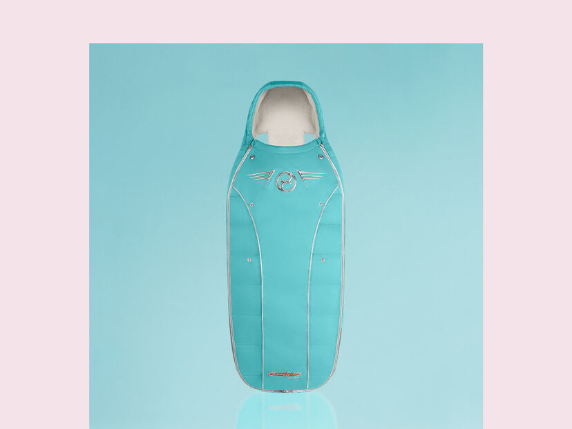 Tyrkysov&yacute; spac&aacute;k s designem kř&iacute;del od Jeremy Scott Wings na světle modr&eacute;m pozad&iacute;.