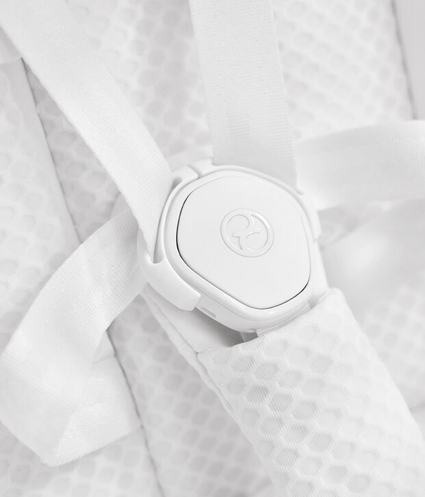 White buckle with textile straps on a textured background.