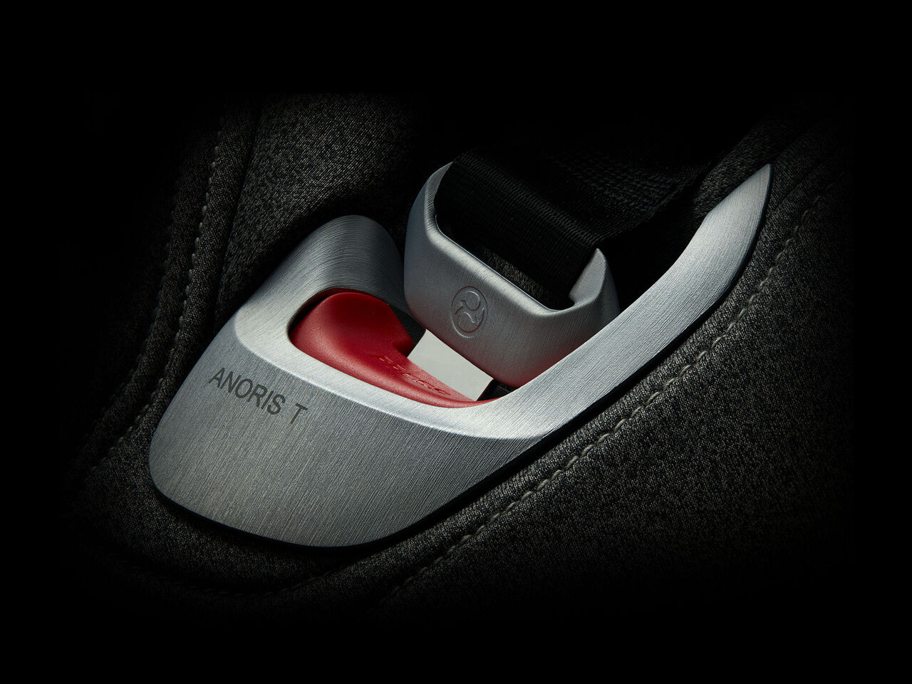 Close-up of Anoris T seatbelt buckle with red button and black strap.