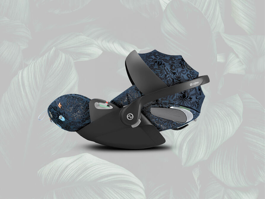 A stylish dark blue Cybex car seat with a floral pattern on a grey background.